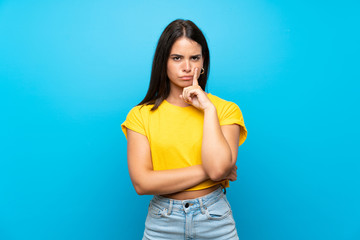 Young girl over isolated blue background Looking front