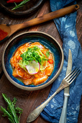 Salmon fillet ceviche with marinated, green, parsley, onion on blue plate. Fresh fish tartare