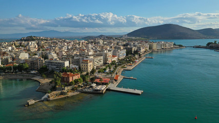 Fototapeta na wymiar Aerial drone photo of famous seaside town of Halkida or Chalkida with beautiful clouds and deep blue sky featuring old bridge connecting Evia island with mainland Greece