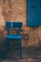 Fototapeta na wymiar une vieille chaise bleue devant un volet bleu