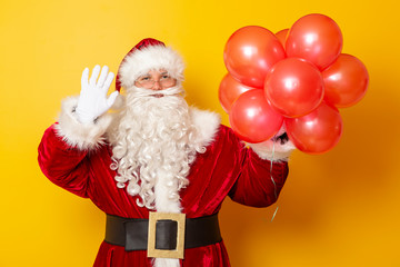 Santa Claus holding balloons and waving