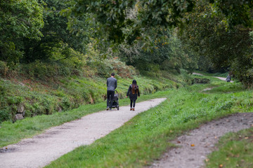 A oung couple with a child walking along a riverside footpath in Cornwall