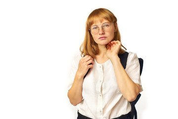 Image of redheaded girl with freckles wearing glasses, white t-shirt and big black backpack looking at the camera