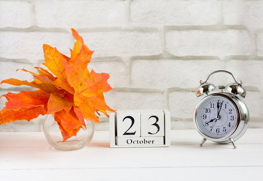 October 23 on a wooden calendar next to the alarm clock, the date of the autumn month.The concept of Golden autumn
