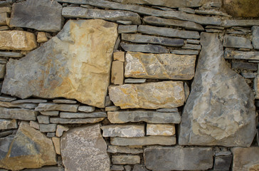 The texture of the stone. Masonry fence. A variety of stone textures in different colors, sizes and shapes.