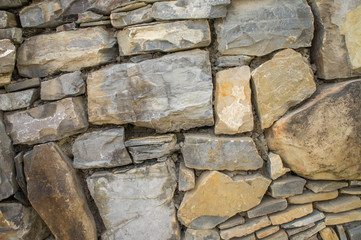 The texture of the stone. Masonry fence. A variety of stone textures in different colors, sizes and shapes.