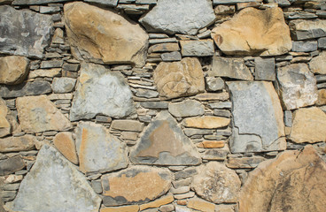 The texture of the stone. Masonry fence. A variety of stone textures in different colors, sizes and shapes.