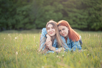 Fototapeta premium Two happy best friends lie on the grass