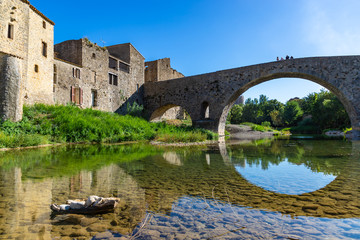 Fototapeta na wymiar Perspective of the Romanesque bridge, was built in the 12th century. Lagrasse, Occitanie, France.
