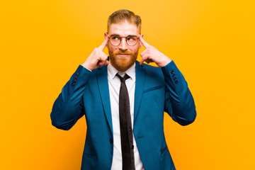 young red head businessman looking concentrated and thinking hard on an idea, imagining a solution...