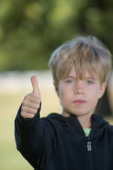 A kid giving a thumb up symbol 