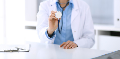 Doctor woman holds stethoscope head close-up. Physician ready to examine and help patient. Medical best treatment, medicine concept