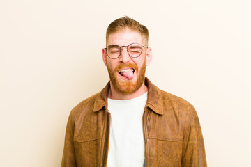 young red head man with cheerful, carefree, rebellious attitude, joking and sticking tongue out,...
