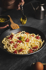 Close-up person mixing pasta with sauce