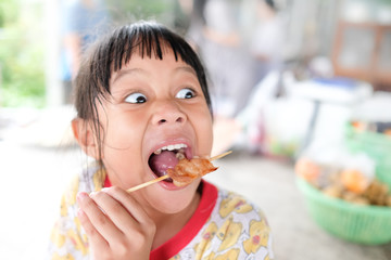 The girls enjoy eating grilled pork.