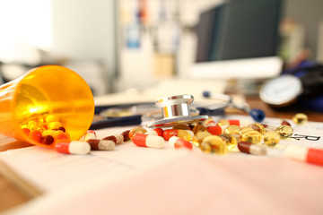 Pile of tablets lying over prescription application form