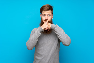 Redhead man with long beard over isolated blue background showing a sign of silence gesture