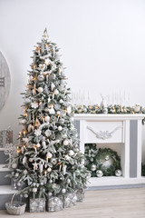 Beautiful New Year's interior with a white fireplace, Christmas tree and garlands