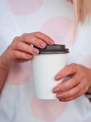 Mockup of woman hand holding a clean Coffee paper cup with copyspace on the cup