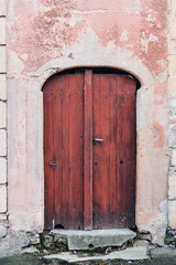 une vieille porte rouge et un mur ancien 