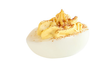 A deviled egg halves sprinkled with paprika and isolated over a white background. Clipping path...