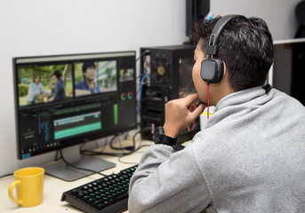 back view of video editor using computer