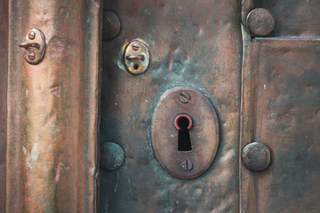 Fototapeta premium Old copper door with key hole and rivets