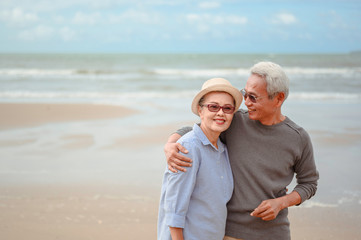 Senior couples embrace the sunrise beach, plan life insurance with the concept of happy retirement.