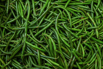 A bunch of fresh green beans background. Organic vegetables at the market. Healthy natural product. Wholesale purchase.