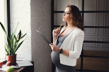 Pregnant mature businesswoman working at office