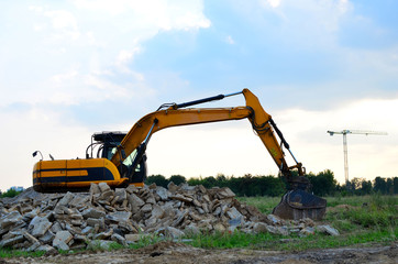 Excavator with crusher bucket for crushing concrete. Construction waste recycling for construction mix. Sifting and grinding bucket for the separation of concrete into fractions of higher quality.