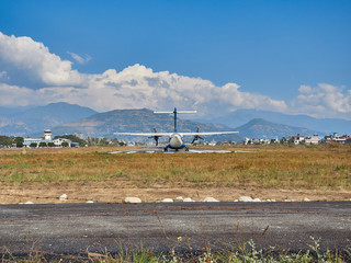 A plane of local, Nepalese airlines on the runway of the airport in Pokhara is preparing for take-off
