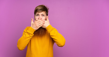 Redhead man with long beard over isolated purple background covering mouth with hands