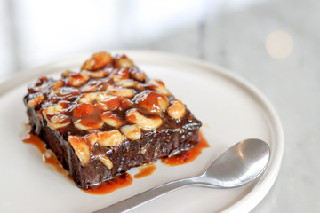 Toffee cake on a white plate with a spoon.