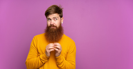 Redhead man with long beard over isolated purple background scheming something