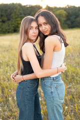 Two beautiful young women hugging on the field under sunlight, Best friends