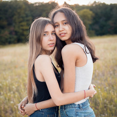 Fototapeta premium Two girls hugging on the autumn field. Best friends
