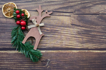 Christmas background from dried oranges, pine twig and decorative deer on a wooden table. Happy new year.