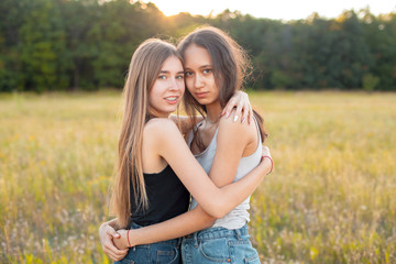 Two adorable girls hugging outdoors, Best friends