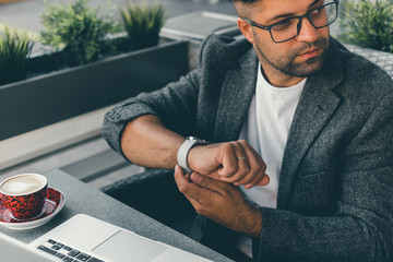 Young beard man using laptop on office, freelance work, outdoor close up hipster portrait, brutal, guy listening music on earphones, make photo and video, production, Bali, watch OS