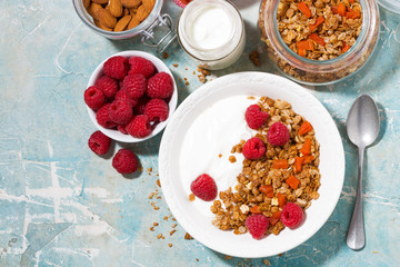homemade granola with dried apricots, raspberries and yogurt, top view