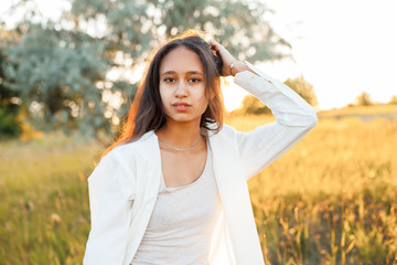 Young woman in white shirt posing outdoors