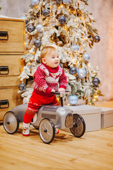 Happy fun child paying with little car at home on Christmas time. Xmas holiday concept