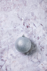 Silver Christmas ball over old white wooden background. Christmas and New year decorations or greeting card. Flat lay, space