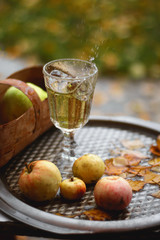 A glass of juice on a tray in the rain, splashing