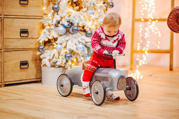 Happy fun child paying with little car at home on Christmas time. Xmas holiday concept