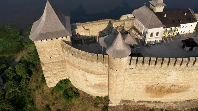 Aerial view of old castle near the River. Hotyn Castle in Ukraine. Eastern Europe. Zoom out.