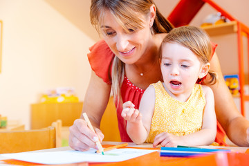Children and play school teacher drawing together