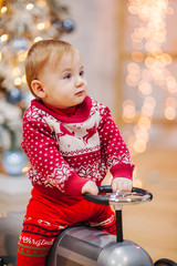 Happy fun child paying with little car at home on Christmas time. Xmas holiday concept