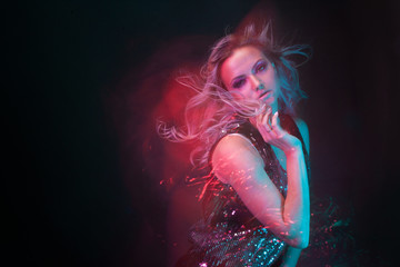 Naklejka premium Attractive dancing blonde in the club, neon light, motion effects